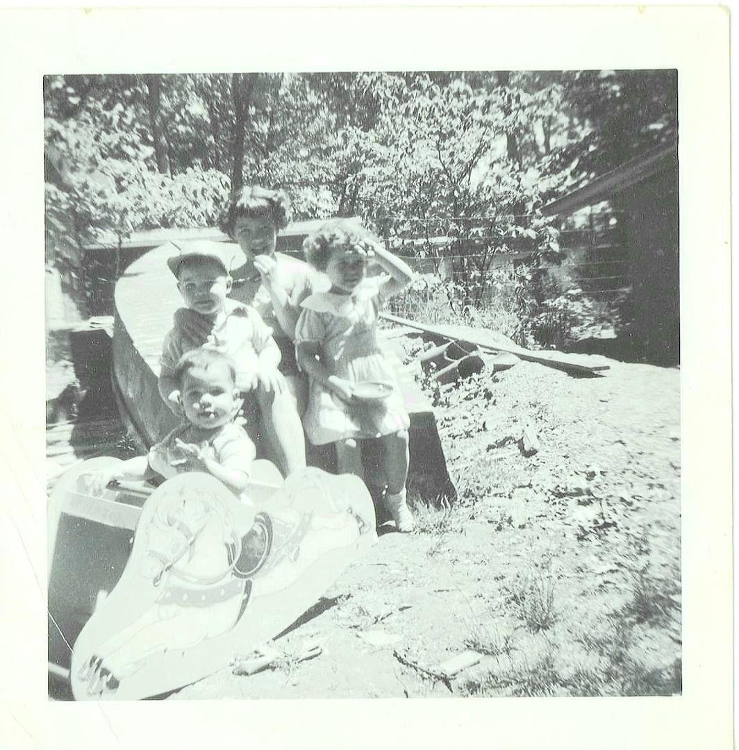 On the boat L to R, Steve,Debbie, Mickey and Me in front 1954 at 939 Lakeside Dr. Waterford, MI.