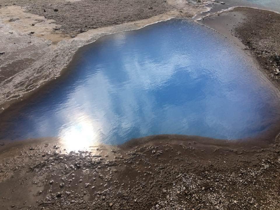 Pale blue, hot, pool adjacent to clear pool. They are even hooked together at top right of photo.