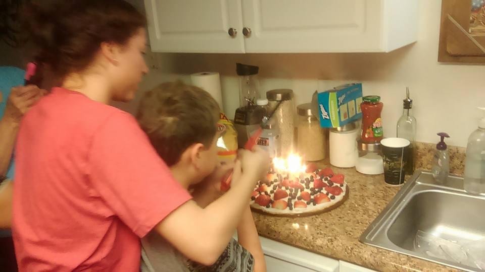 Jade and Colton trying to set fire to their dad's birthday cookie.