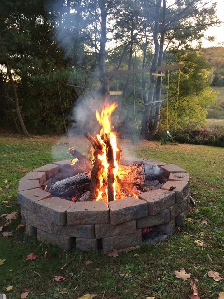 Sitting around fire pit with family and friends having drinks and dinner.