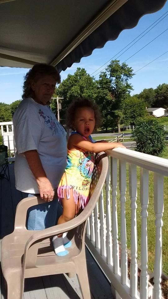 Gigi and Skyla watching Poppop mow the lawn