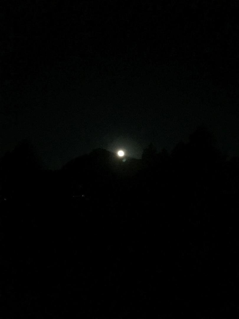 “The Special Giant Moon” over a dirt parking lot or a button over the same parking lot.