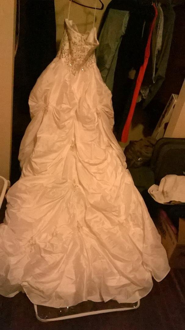 It's white in color. Custom sized roughly a size 20 and its way to long for me even in heels and I'm 5'3. Strapless wedding gown. Pictures don't do it justice asking $300 obo