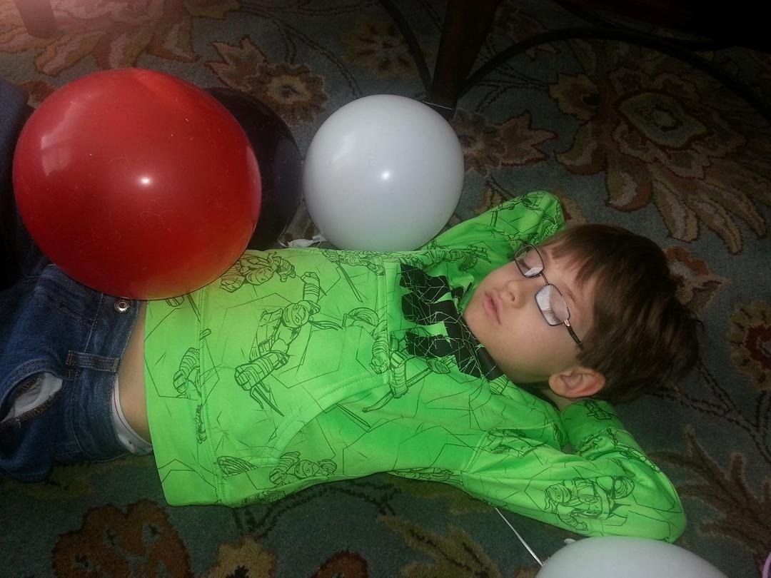 Here is the birthday boy, sound asleep on the floor with his birthday balloons. He got home from school and that was all she wrote. Lol.