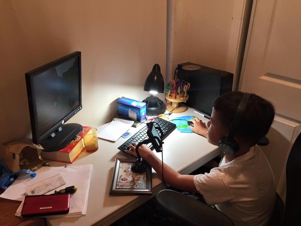 Bry playing mindcraft with friends from all over, note his cell phone mounted on my old car phone brkt mounted on a 5X7 photo frame, "Tennessee engineering" been around His big brother