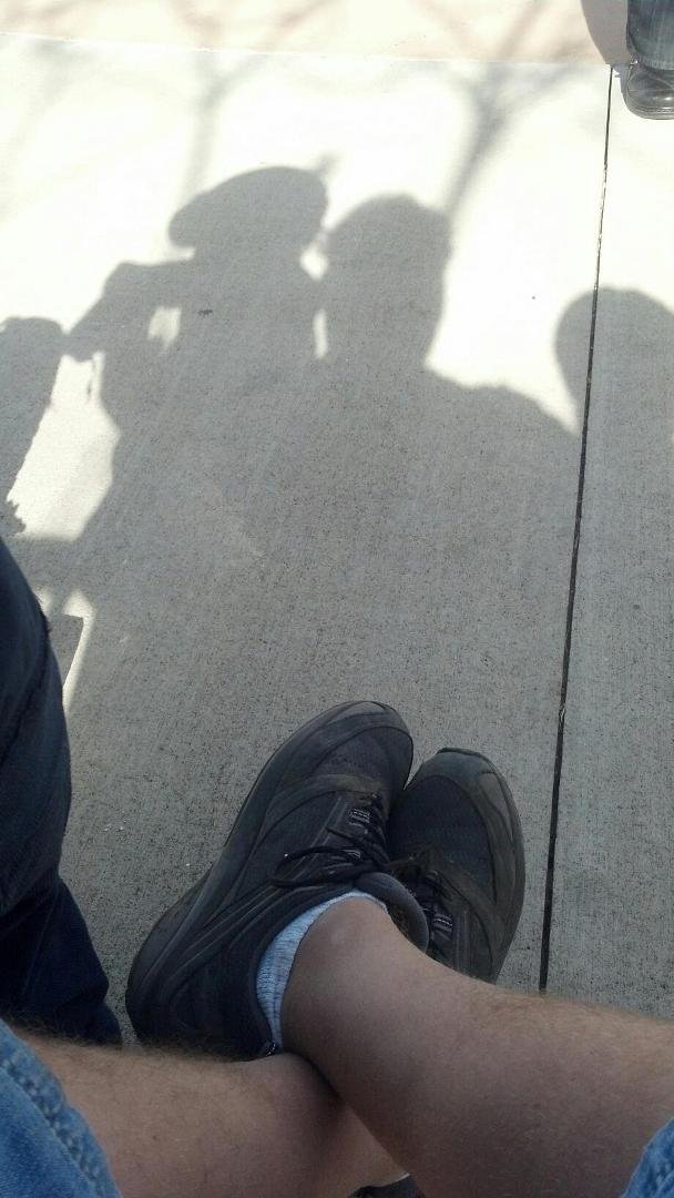 My son takes a picture of our shadow.