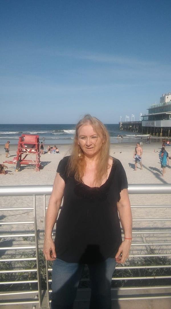 Me at Daytona Beach yesterday with Darren Melissa Helen Randall. Darren"s band STRUT was playing there for bike week. The sun was in my eyes could not see to good and the wind was blowing my hair every which way.