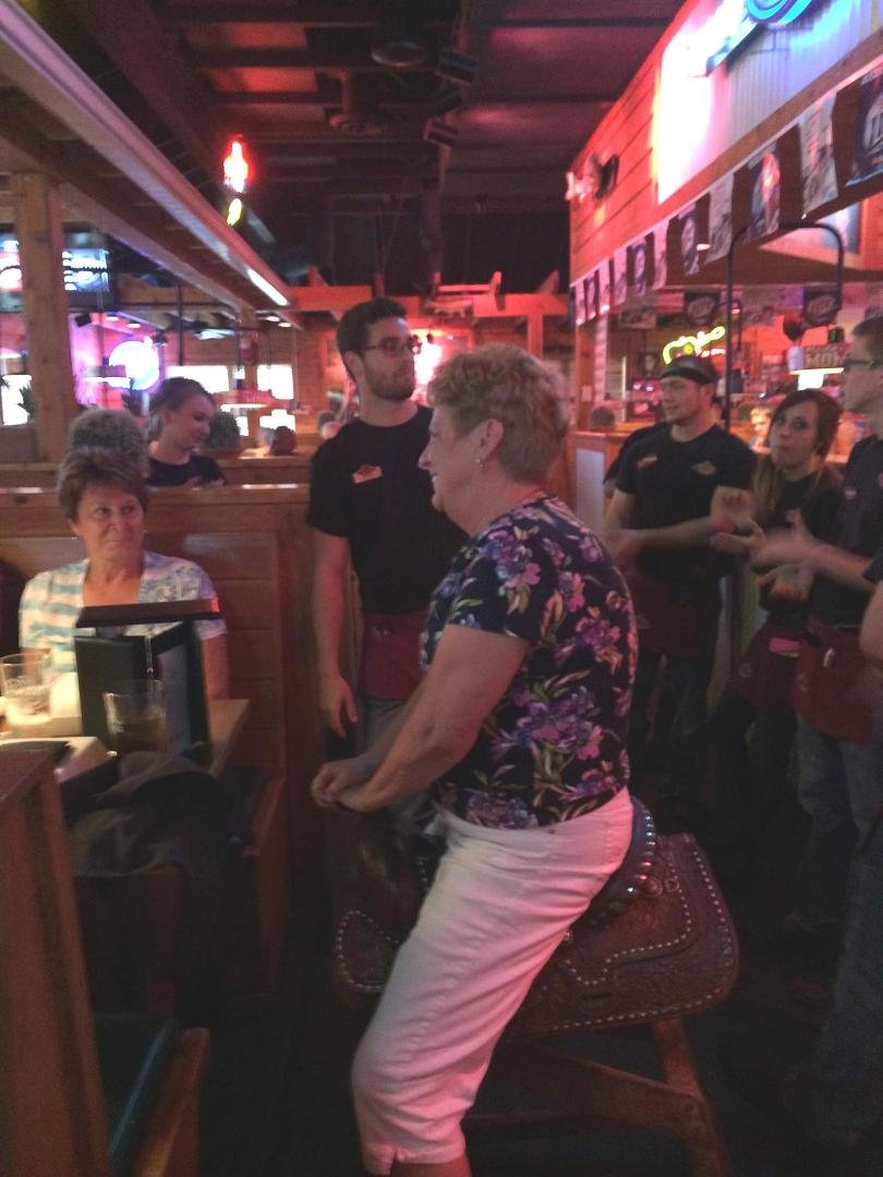 Jeannie riding the saddle at Texas Roadhouse on her birthday.