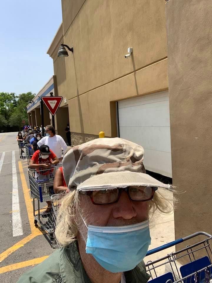 The new normal standing in line in the sun waiting to get in the store