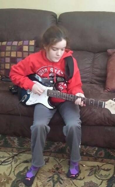 Liv practicing guitar.