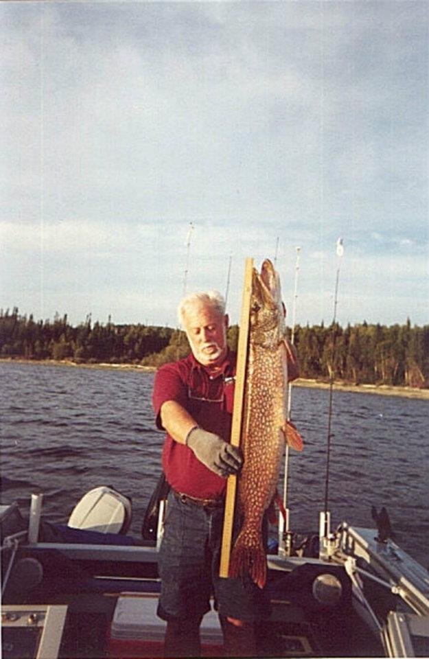 Me with a forty + Pike being measured with a metric stick at Lac Seul Ontario, Canada in my boat called the Eagle's Nest