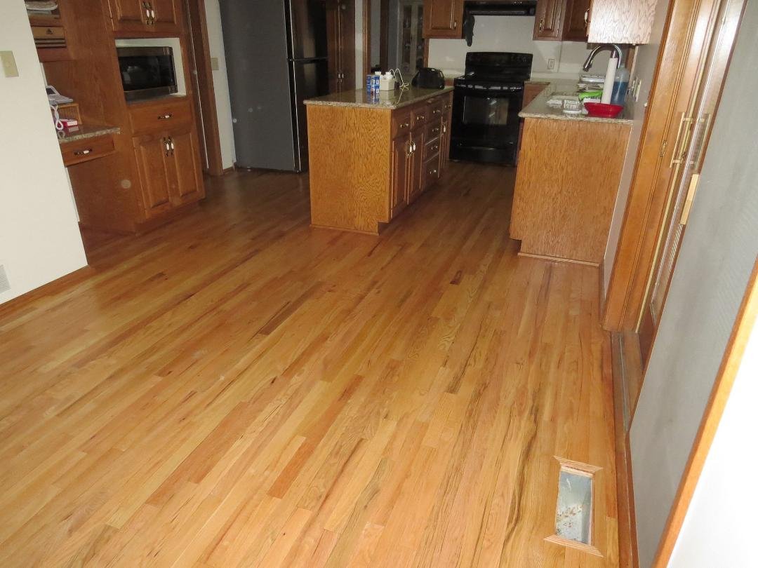 Refinished wood flooring in the kitchen and dinette area. This picture was taken a few days after the flooring had been sanded, newly stained, and varnished. At the time this picture was taken, the new cabinetry around the