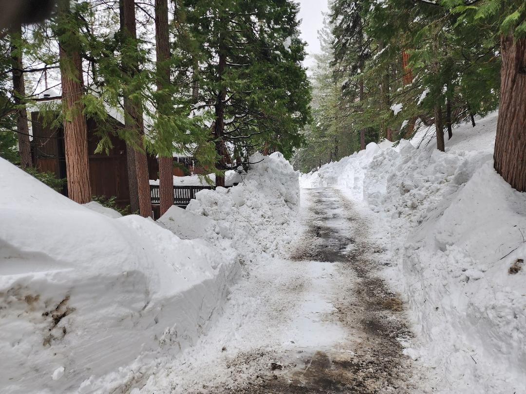 After 8 days of no plowing, our access road was just done (not very well, but at least the plow driver gave it his best shot). Single lane, no place to turn around.