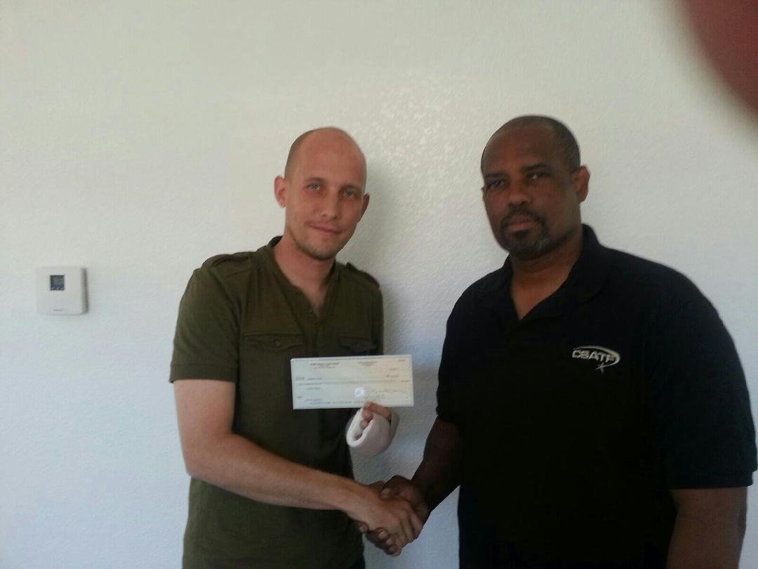 Sgt. Sawyer receives a check from Colen Young on behalf of the National Staff Assault Task Force.