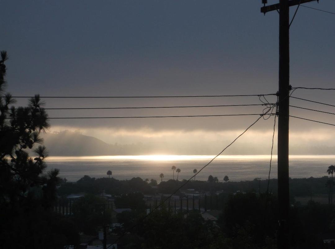 The sun is rising out of the lake.