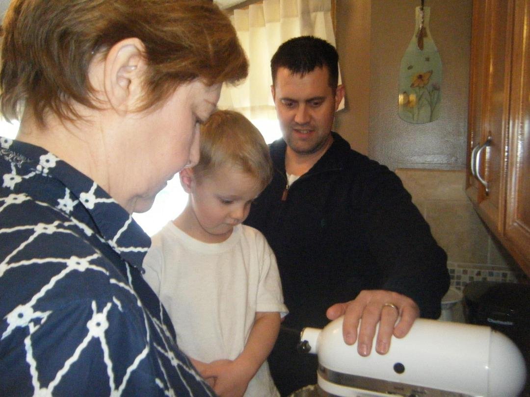 Grandma is stirring the batter, Lucas and Mike are watching.
