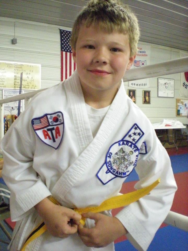 trying to get his square knot. New belts are stiff