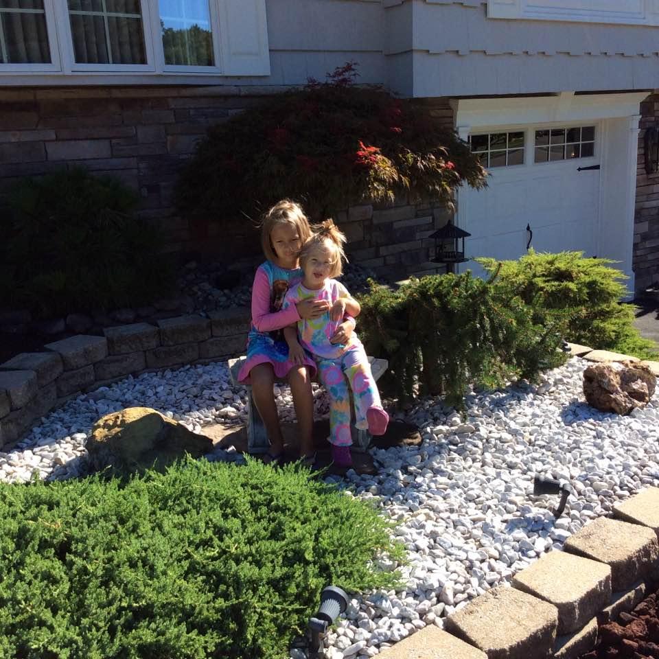 Connecticut grandkids, Catherine and Charlotte sitting in Pockey and Grandma's garden.