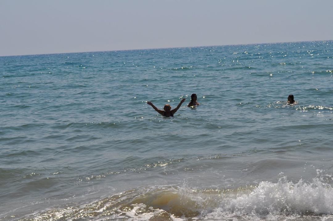Pina waves to the camera at Scoglitti beach.