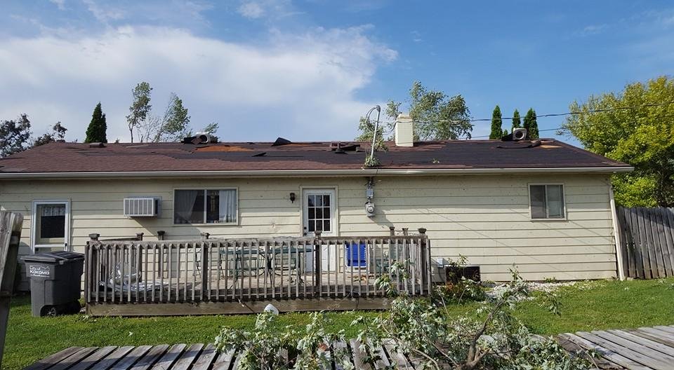 Our neighbors house. Her house faces Mohr Dr. Alot of shingles were off plus most of her fence was down and some of her trees by out drive are knocked over.
