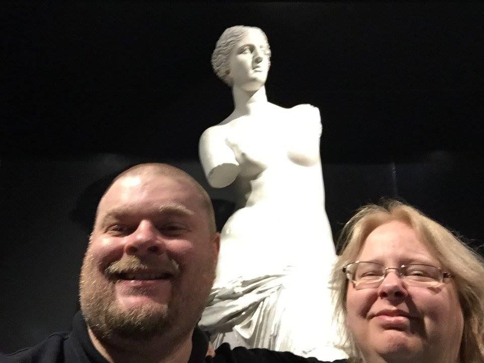 Brad and Paula Mitzel in front of a sculpture in the hallway of the subway outside of the Louvre in Paris, France