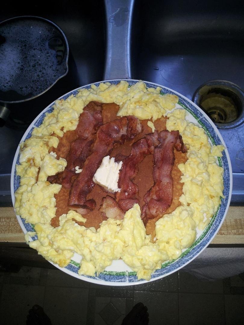 Mine and Wills breakfast . Plate size pancake eggs and bacon