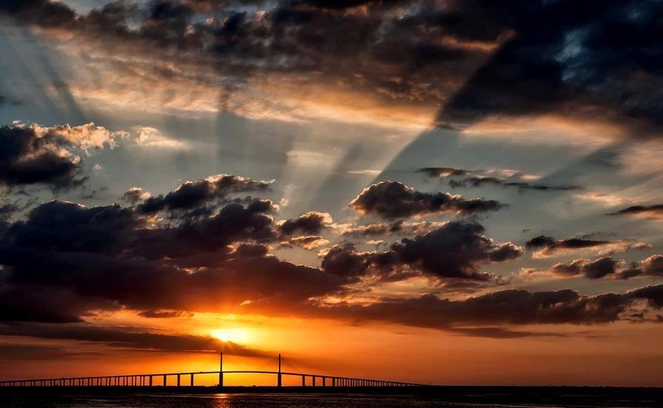 Awesome shot of the clouds with the light radiating through them over the Skyway Bridge