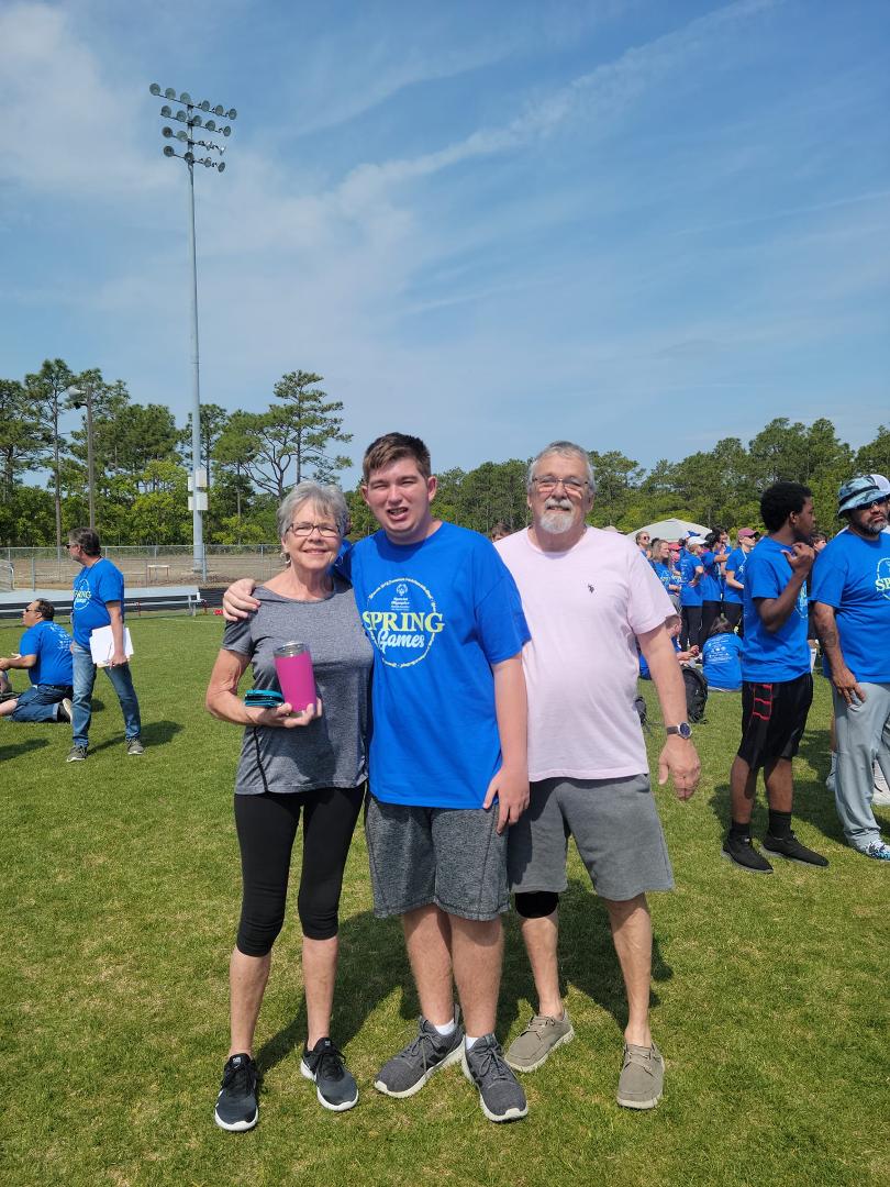 Aaryn with papa and mama at special Olympics. Had a great time.