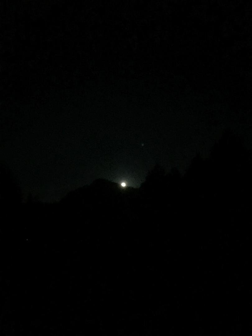 “The Special Giant Moon” over a dirt parking lot or a button over the same parking lot.