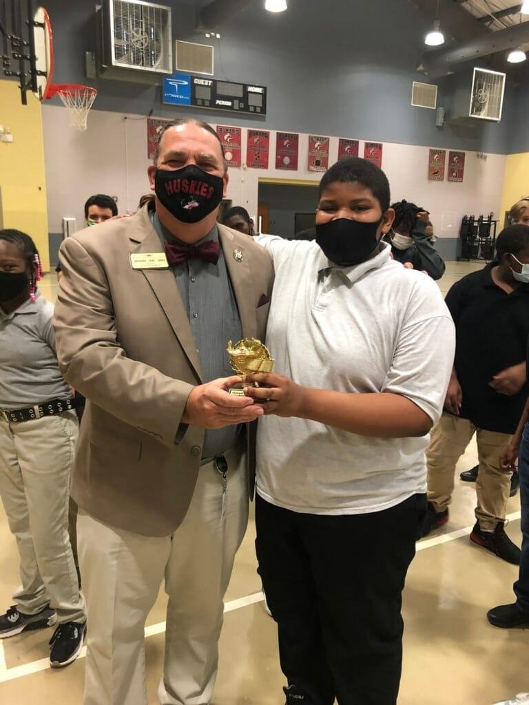 Ryan accepting award from principal jones at howard middle