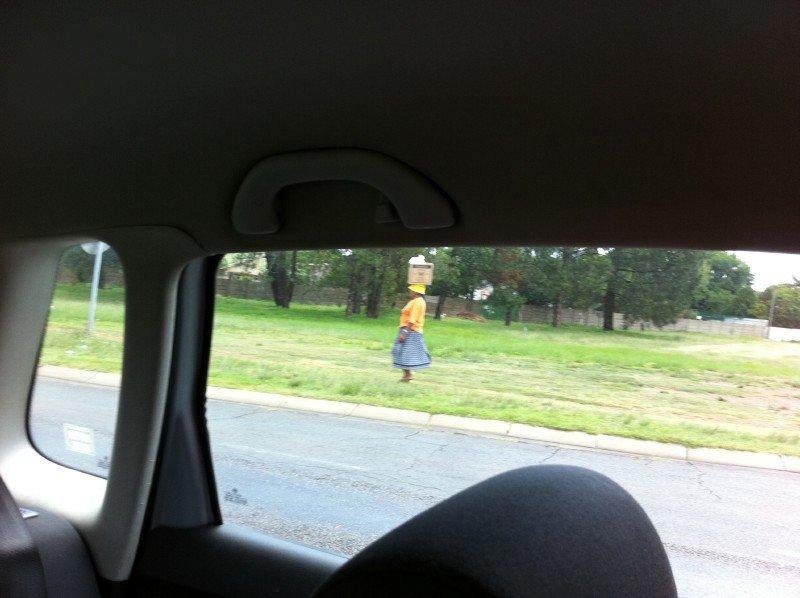 South African woman with groceries on her head.