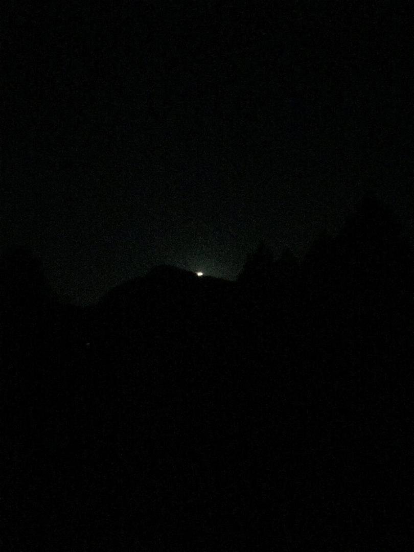“The Special Giant Moon” over a dirt parking lot or a button over the same parking lot.