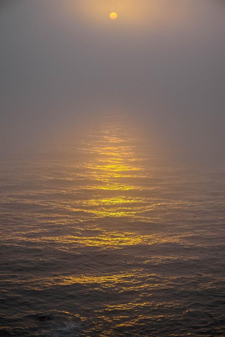Setting sun along foggy California coast