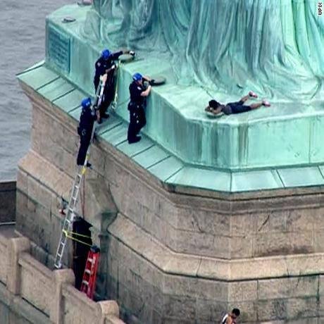 Woman climbs base of the statue of Liberty on July 4---
Point and woman taken.