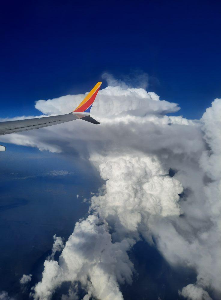Flying from Dallas to Denver for the umpteenth time on Sunday. -don't see this much-plane just below high cloud level-NM-Colorado border. (while following Southwest flight tracker in flight).