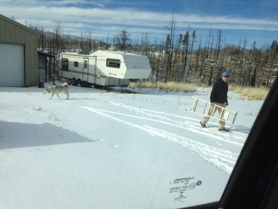 After the fire photo. Where the house was on behind my son   Amazing that the garage/shed was still standing. See my wonderful grand dog, she loves the snow.  It's been 5 years since the fire and the first time I was able t