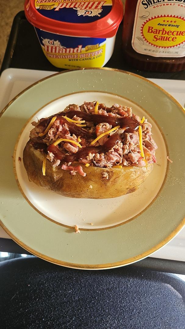 Labor day dinner, homemade baked potato, with butter, cheese and pulled pork.