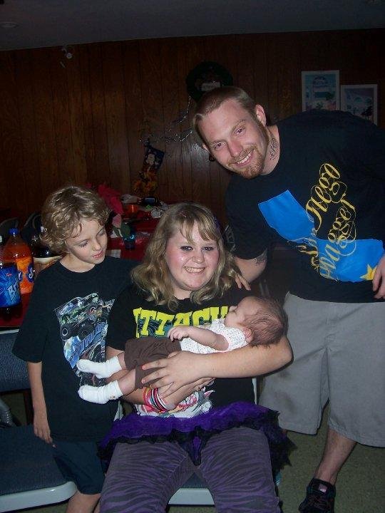 Heather holding Baylee and not nervous at all, Rich happy he isn't holding the baby and Timmy looking on