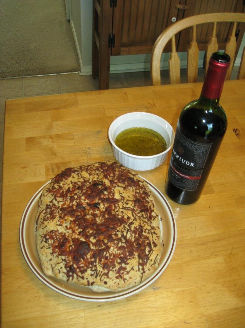 Homemade Focaccia bread, dipping oil (made with olive oil, garlic,parmesan, and oregano), and a nice cab sav.