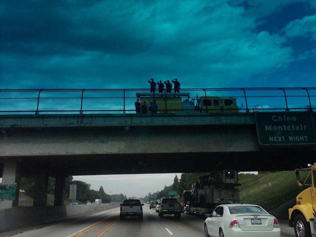 Firefrighters saluting their fallen Brothers from 9-11. If you closely you can see a snorkel truck and part of the towers being transported to Yorba Linda this morning.