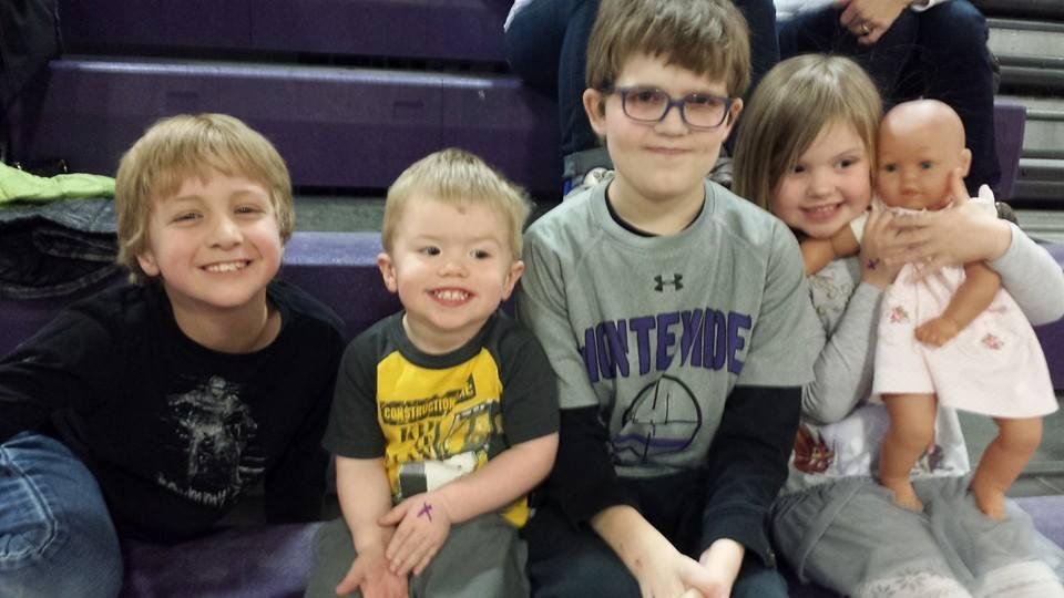 Cousins watching Ashton ' s 6th grade basketball game.