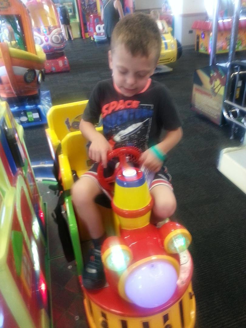 Cameron, my older nephew, riding a ride at Chuck E. Cheese