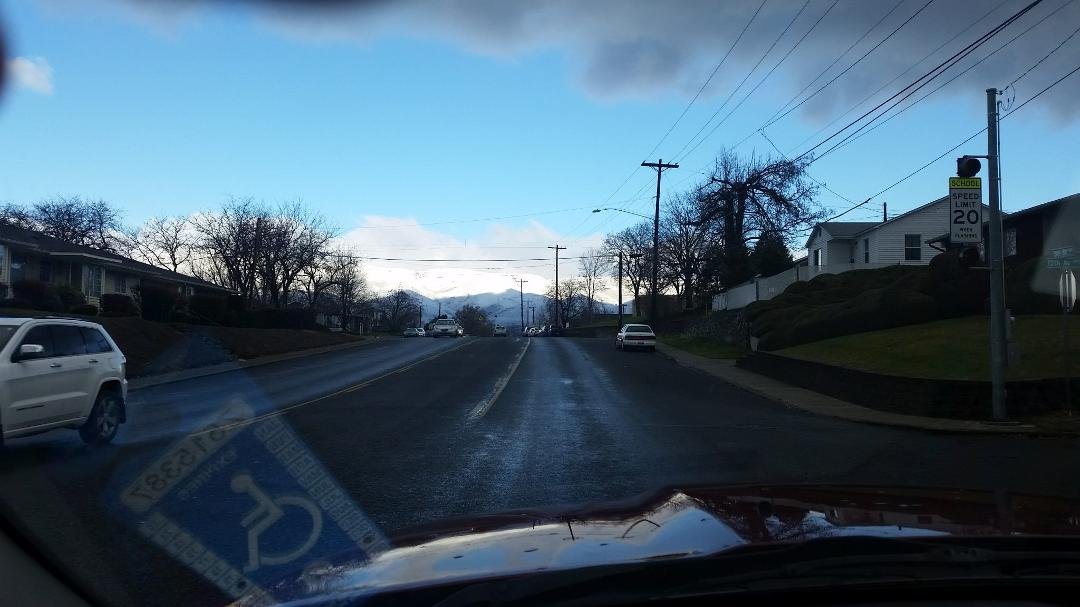 traveling down the street in lewiston idaho..mountains in the distance are covered in snow.