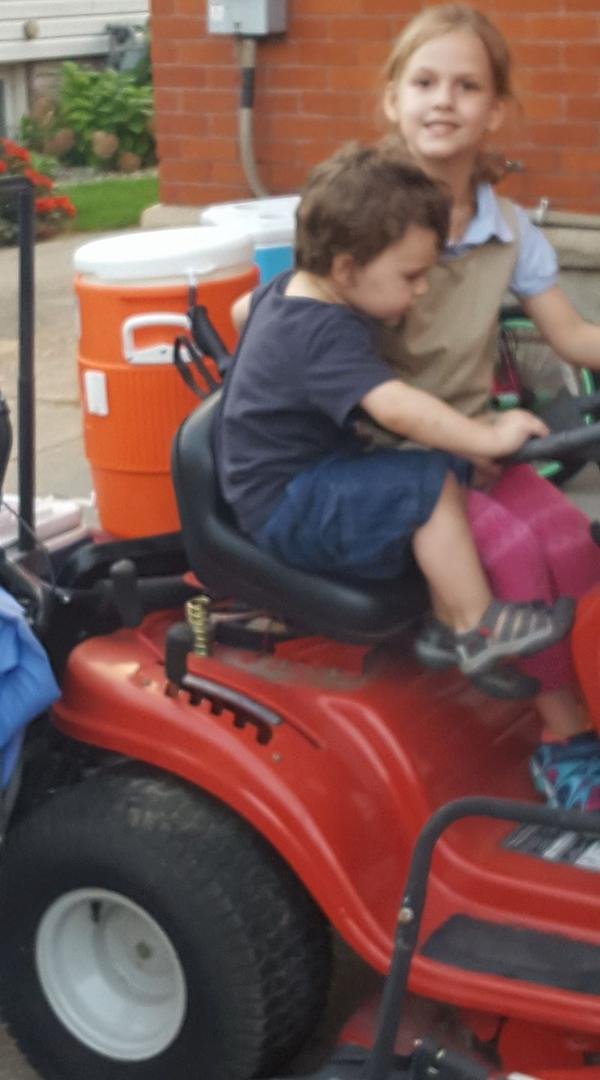 My grandson and granddaughter enjoying playing on my lawn tractor