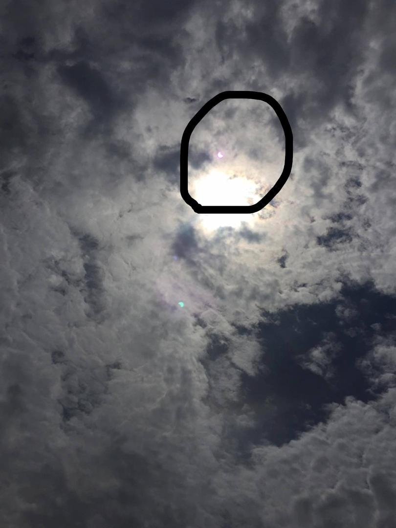 I'm here in Horton Kansas it's a bit cloudy but I did capture part of the eclipse... look above the bright cloud and you will see it kinda outlined in purple. Enlarge the ive circled