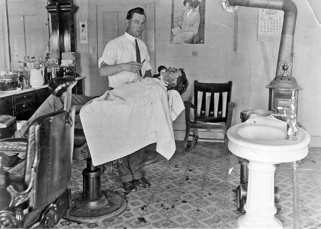 Yesterday, I posted a photo of my grandfather, Roy Hardgrave, in front of his barber shop, in Dalhart, Texas, in 1914. Here is a sequel to that neat photo.......a view inside that barber shop, and showing Roy shaving his y