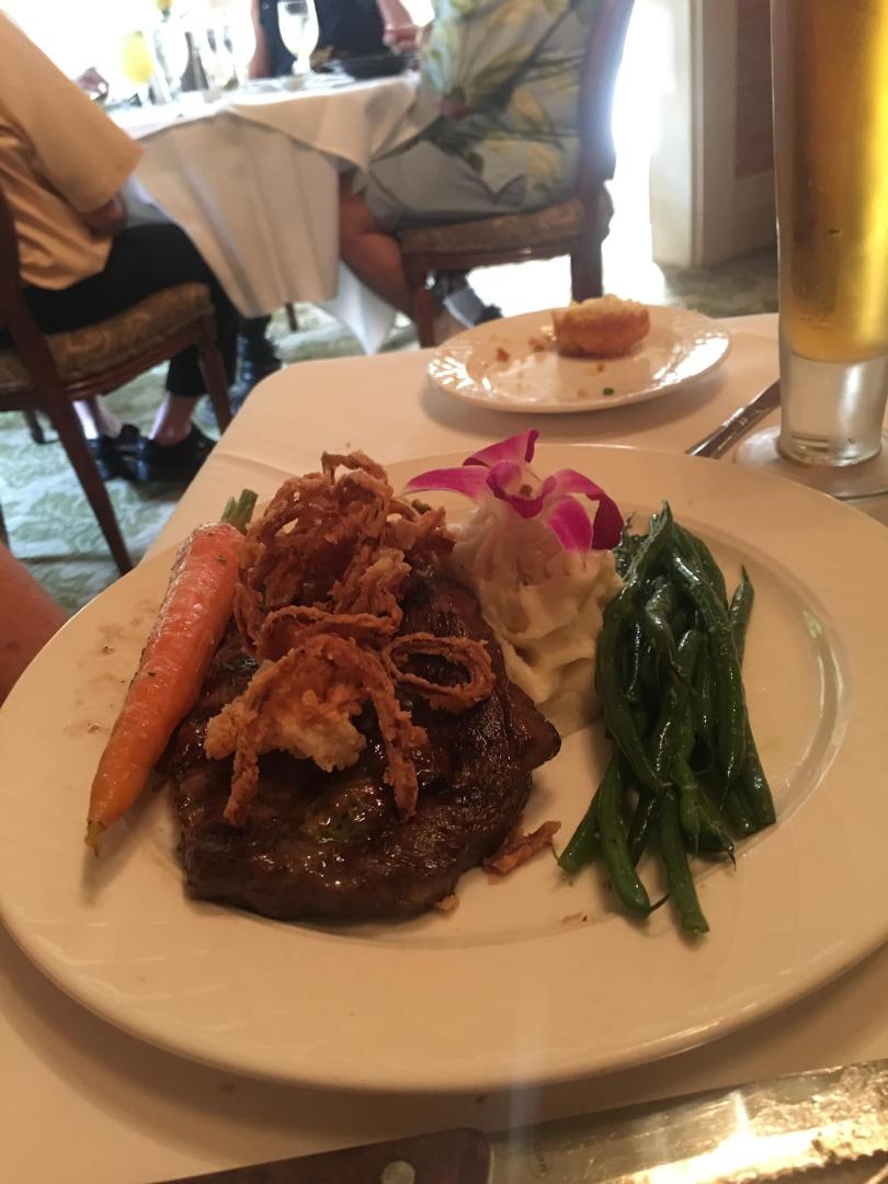 Grilled Black Angus Ribeye Steak finished with compound herb butter and onion straws