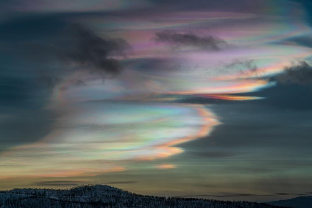Nacreous Clouds over Lapland
Image Credit & Copyright: Dennis Lehtonen
Explanation: Vivid and lustrous, wafting iridescent waves of color wash across this skyscape from Kilpisjärvi, Finland. Known as nacreous clouds or mot