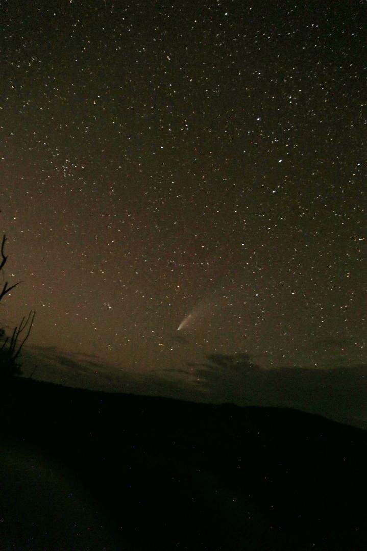 Comet NEOWISE just above the clouds with the setting crescent Moon below the clouds on the left. You can see the Big Dipper above and right of the comet.