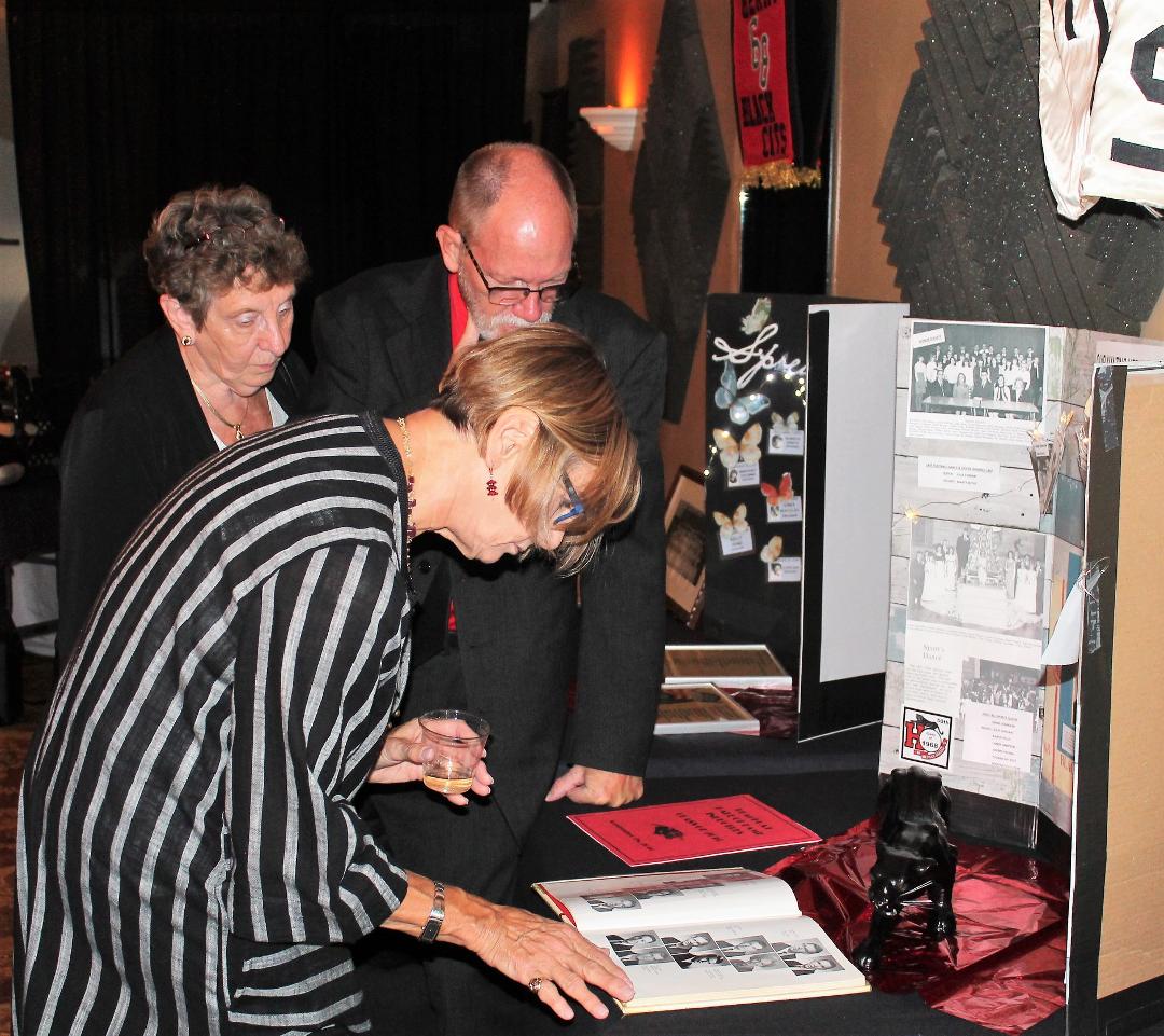 Karen Kelley and Mike Wade and wife check out old yearbooks
